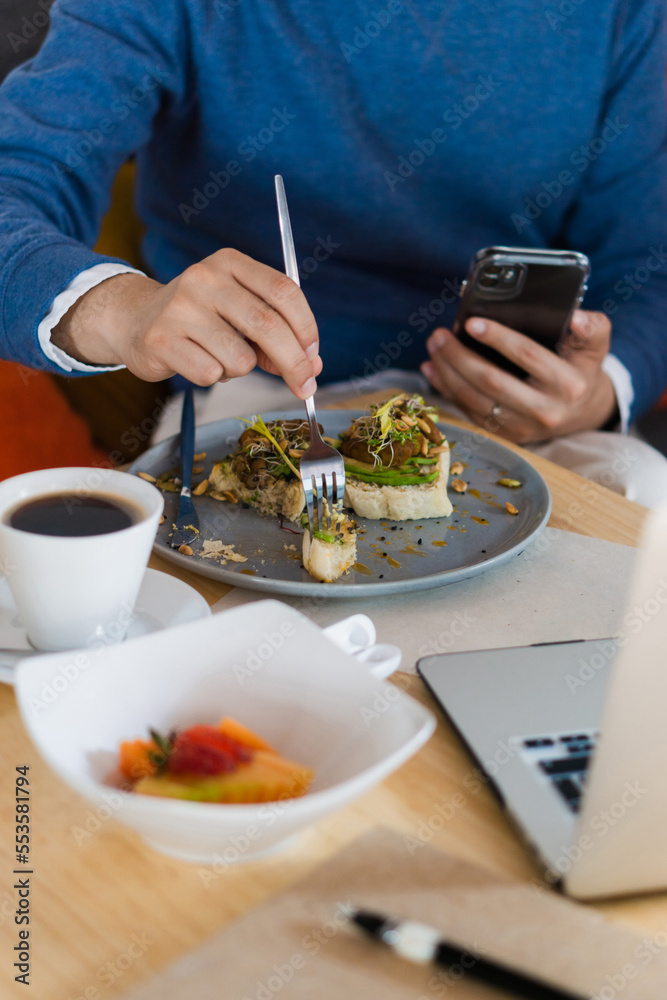 Hands of unrecognizable man in formal wear having breakfast in a restaurant. Business. Hands of unrecognizable man in formal wear having breakfast in a restaurant. Business.