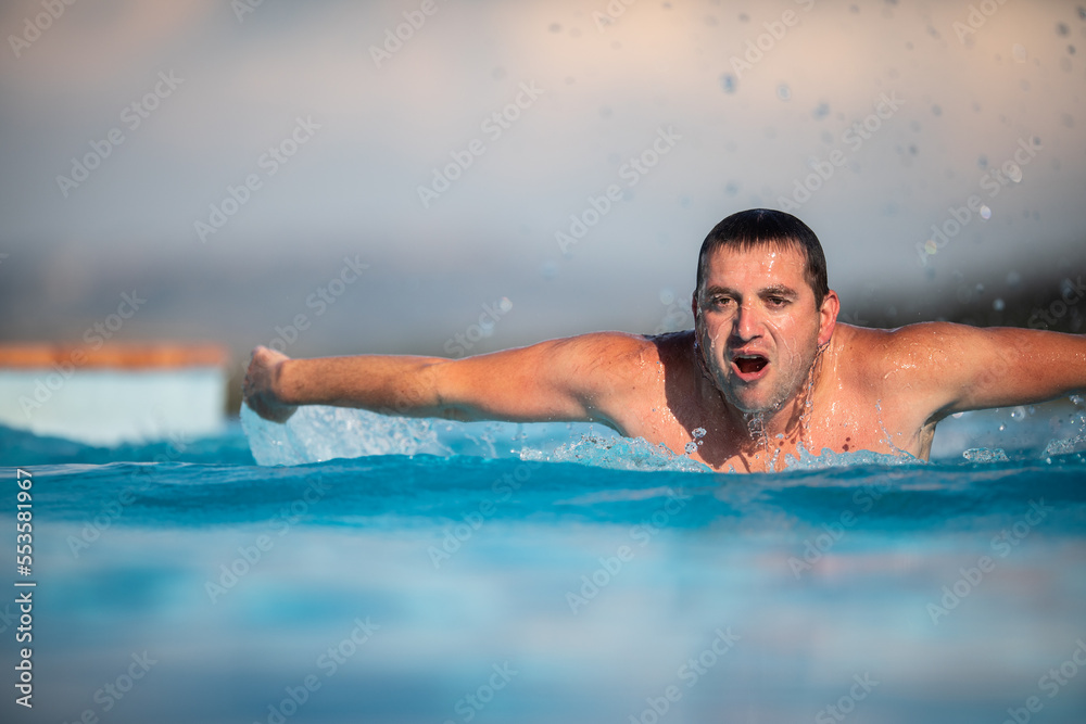 Male swimmer swimming in an outdoor pool - keeping fit