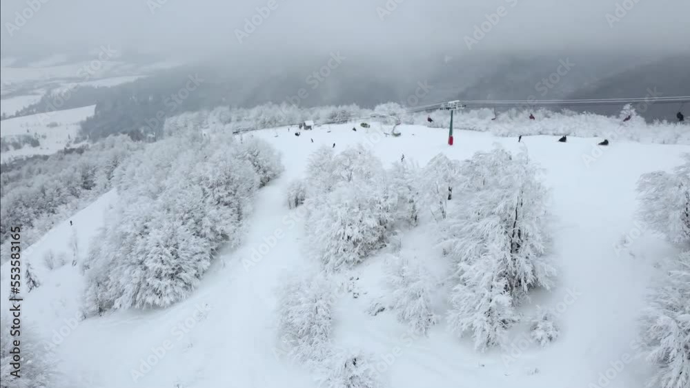 People skiing and snowboarding on snow slope in winter ski resort. Ski elevator on snow mountain. Winter activity. People skiing and snowboarding on snow slope in winter ski resort. Ski elevator on snow mountain. Winter activity.