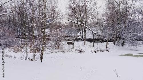 Well crane behind a snowy pond, Mamajeva Sloboda Cossack Village, Kyiv, Ukraine photo