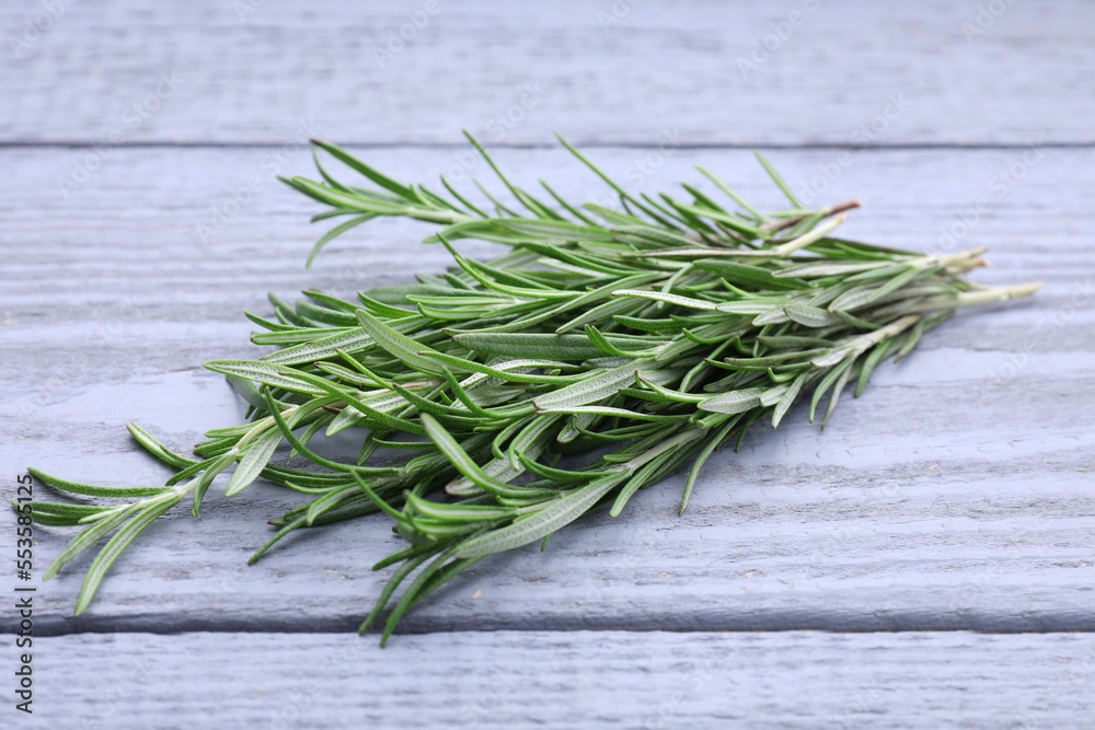 Sprigs of fresh rosemary on wooden table Sprigs of fresh rosemary on wooden table