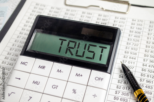 calculator with the word TRUST on display with chart