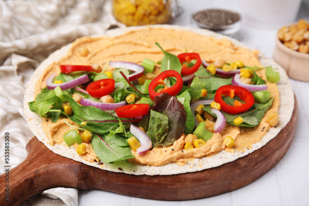 Tortilla with hummus and vegetables on table, closeup Tortilla with hummus and vegetables on table, closeup