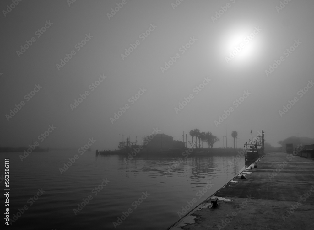 Foggy dock with sun background in monochrome