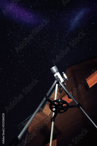 Modern telescope and beautiful sky in night outdoors, low angle view. Learning astronomy