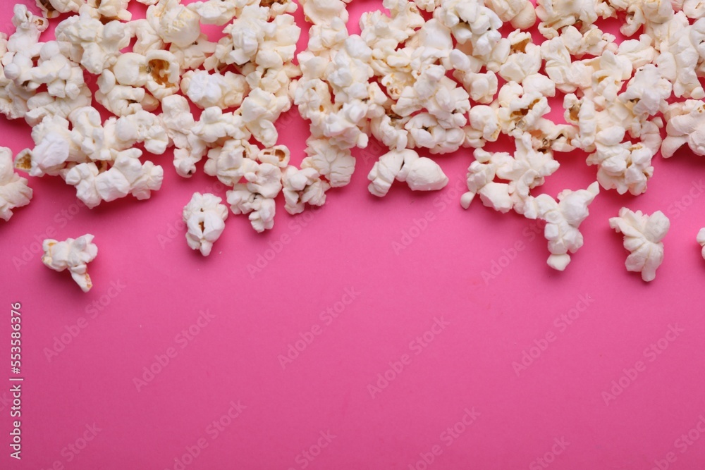 Tasty popcorn on pink background, flat lay. Space for text Tasty popcorn on pink background, flat lay. Space for text