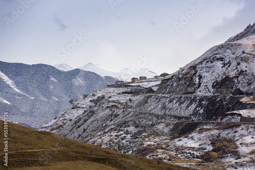 Houses on top of the mountain. Fantastic high rocks. Caucasus Mountains in Dagestan, Russia. Panoramic view of the Caucasian ridges and sharp rocks