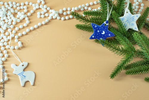 New Year stars and deer against the backdrop of spruce branches and white beads