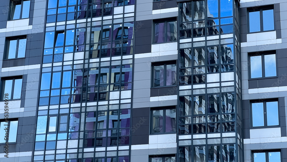 Modern facade of a new residential complex, blue glass facade glazing. Residential apartments or architecture of an office building Modern facade of a new residential complex, blue glass facade glazing. Residential apartments or architecture of an office building