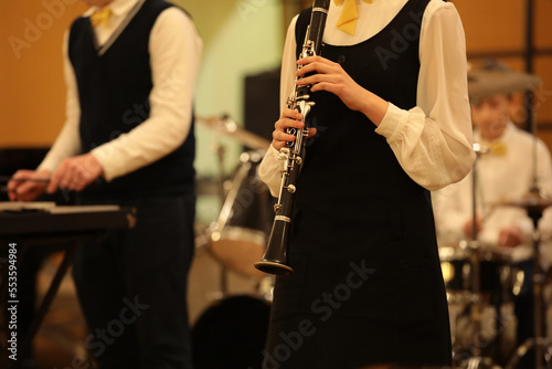 A girl playing clarinet in a school orchestra at a concert