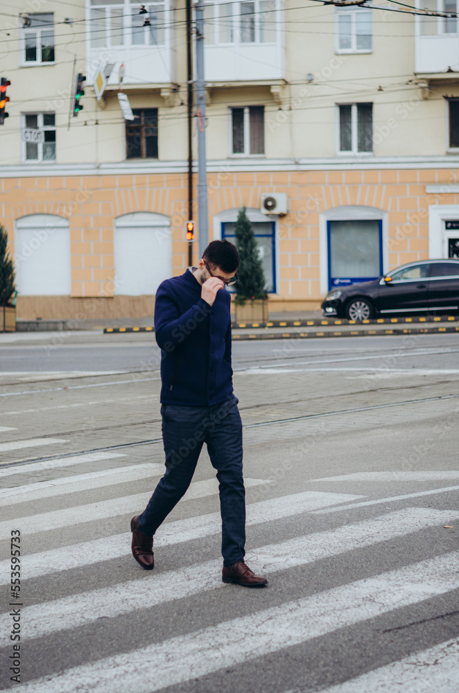 a man with glasses in his hand crosses the road a man with glasses in his hand crosses the road