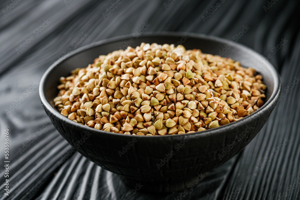 organic raw green buckwheat on a black background