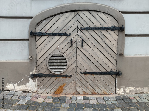 Small old wooden door withn iron hinges. Building in Old town of Riga, Latvia. photo