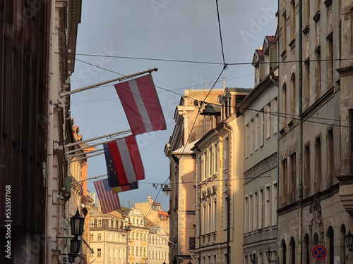 European architecture of Old town of Riga Latvia. Buildings in sunlight. Flags of Latvia, Austria, Germany, USA and EU on wall.