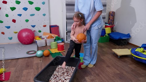Kid on Sensory Mat Massage during sensory integration session. child girl in rehabilitation centre with physiotherapist doing orthopedic correction. 