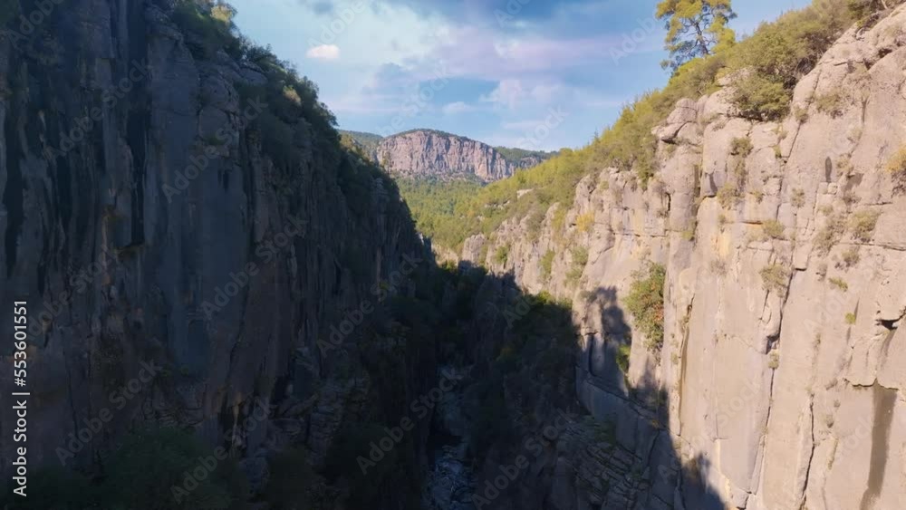 Flight between rocks in a mountain gorge. Drone video footage. Green plants on gray rocks. Canyon Flight between rocks in a mountain gorge. Drone video footage. Green plants on gray rocks. Canyon