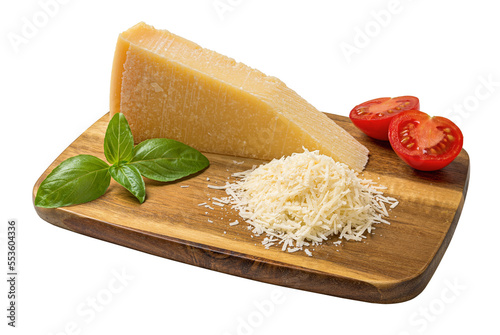 Whole and grated parmesan on a cutting board cutout. Grana padano wedge, grated cheese, basil and halved tomato on a wooden shopping board isolated on a white background. Dairy product.