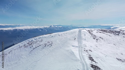 Aerial view of a mountain slope used for freeride skiing. Visible snowcat tracks on the egde and summit. Ski and snowboard tracks on the powder snow. photo