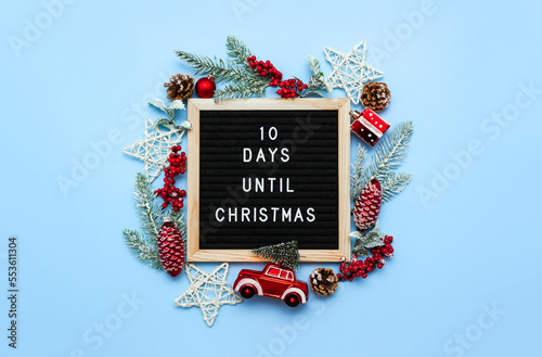 Felt letterboard with countdown surrounded by winter decoration on blue background. 10 days until Christmas. Twenty-four day series of postcards. Selective focus