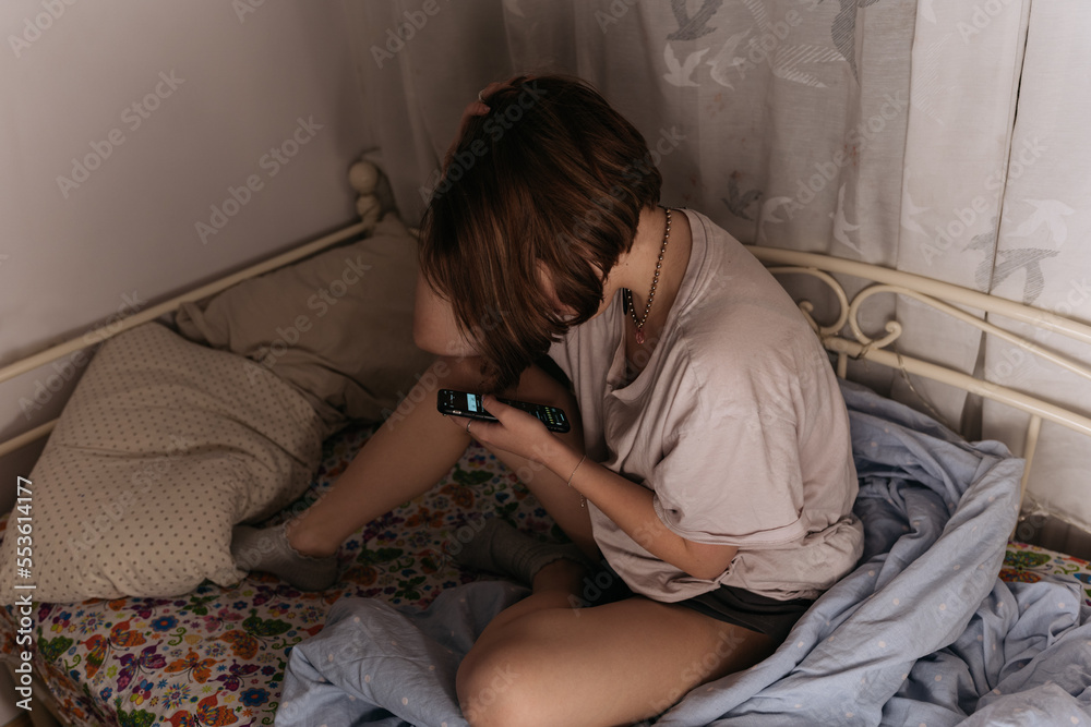 custom made wallpaper toronto digitalTeenager girl sitting in her bed with a smartphone