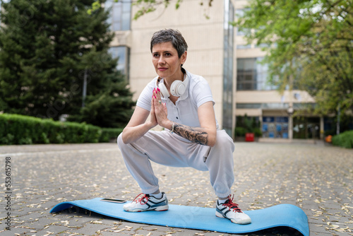 One mature Caucasian woman senior female practice yoga outdoor