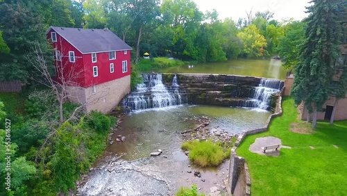 Aerial up close to waterfall by red barn in small town in New York Honeoye Falls photo