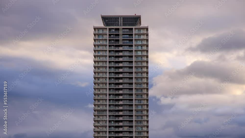 Fast moving clouds over luxury apartment tower at sunset Fast moving clouds over luxury apartment tower at sunset