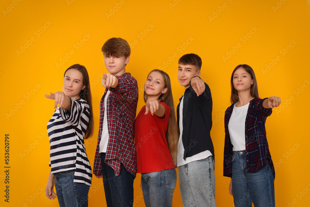 Obraz premium Group of happy teenagers on orange background