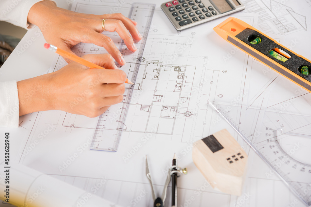 Architectural project workplace. Architect drawing with ruler on house plan blueprint paper for repair tools on table desk at architecture office, architect sketching construction, Engineering tools Architectural project workplace. Architect drawing with ruler on house plan blueprint paper for repair tools on table desk at architecture office, architect sketching construction, Engineering tools