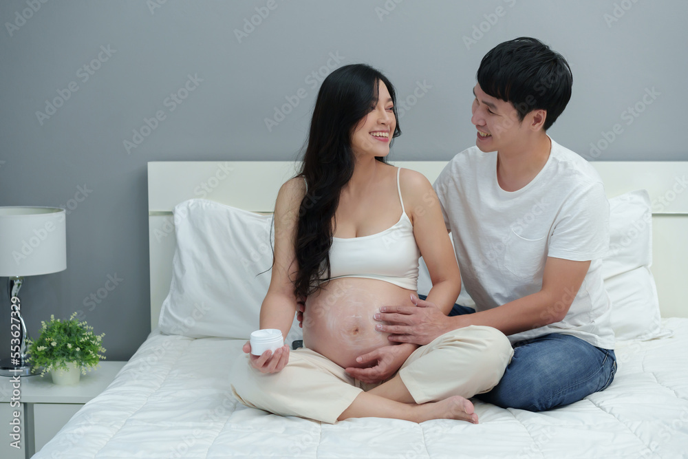 pregnant couple stroking apply cream on belly for beauty moisturizing skin on bed pregnant couple stroking apply cream on belly for beauty moisturizing skin on bed