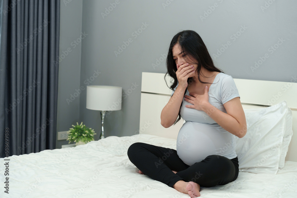 pregnant woman feeling nauseous on bed pregnant woman feeling nauseous on bed