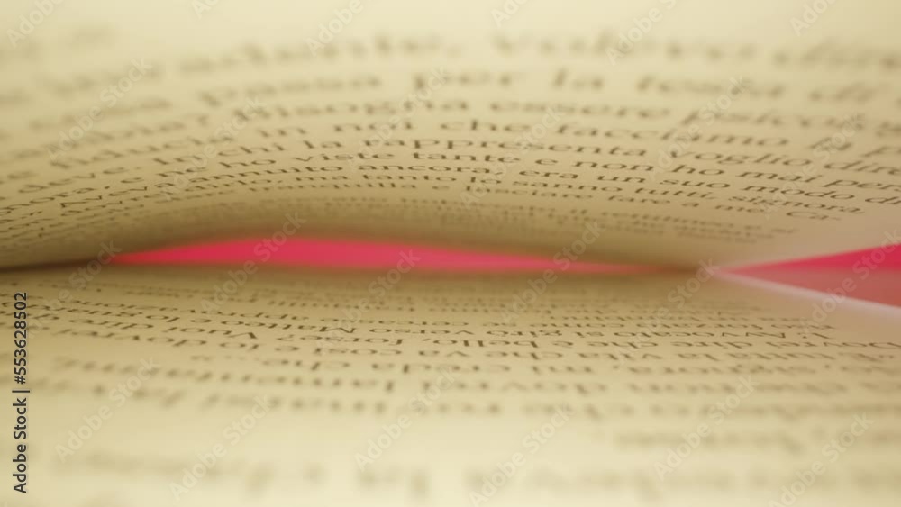 Narrow gap between stacked yellowed book pages with black ink on bright pink wall background in studio room macro backward motion
