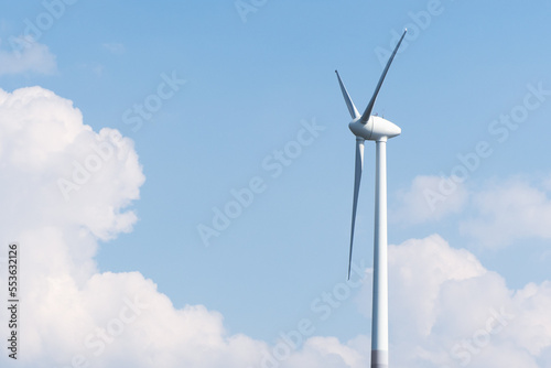 Wind turbine against a light blue sky with white clouds in Bavaria, Germany
