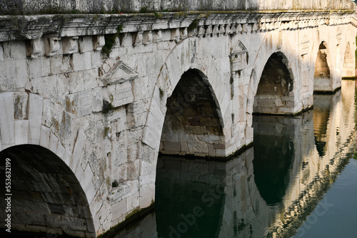Arches of the Tiberius Bridge in Rimini, Italy, and their reflection in the Marecchia river