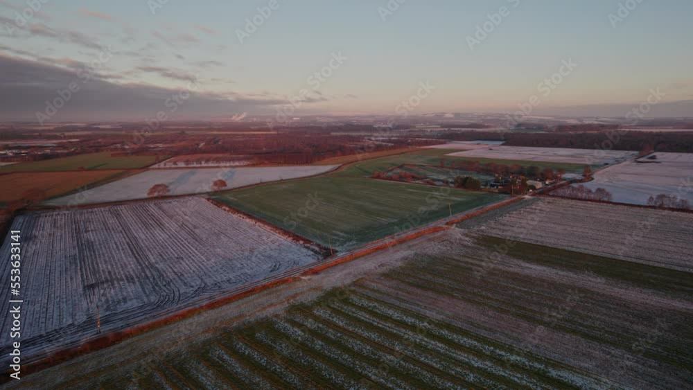 Aerial drone view of snow filled ploughed farm fields in English countryside at sunset Aerial drone view of snow filled ploughed farm fields in English countryside at sunset