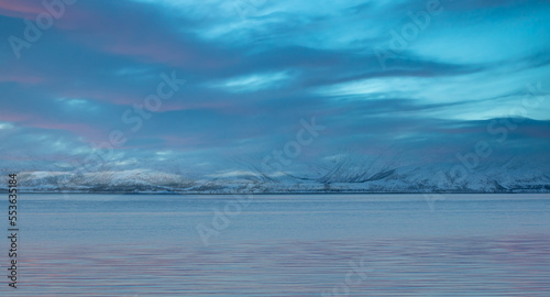 Fototapeta Naklejka Na Ścianę i Meble -  Panoramic view at fjord with coast of the Norwegian Sea, snowy mountains in the background   Arctic Circle at sunset - Norway