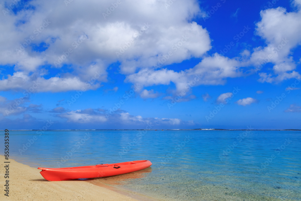 An orange kayak on a beach, with a beautiful blue tropical lagoon behind it. Aroa Beach, Rarotonga, Cook Islands An orange kayak on a beach, with a beautiful blue tropical lagoon behind it. Aroa Beach, Rarotonga, Cook Islands