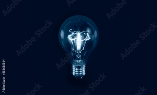Burning candle in the light bulb isolated on black background