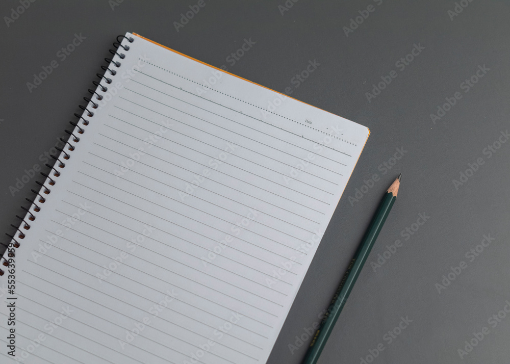 white note pad with a pen on grey background white note pad with a pen on grey background