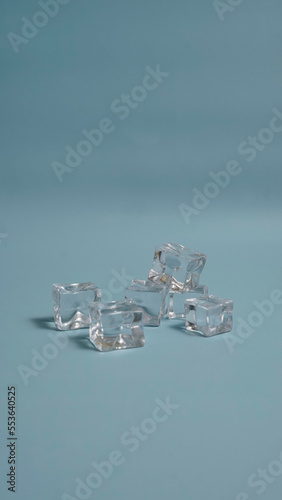 Stack of cold ice cube in an empty blue background