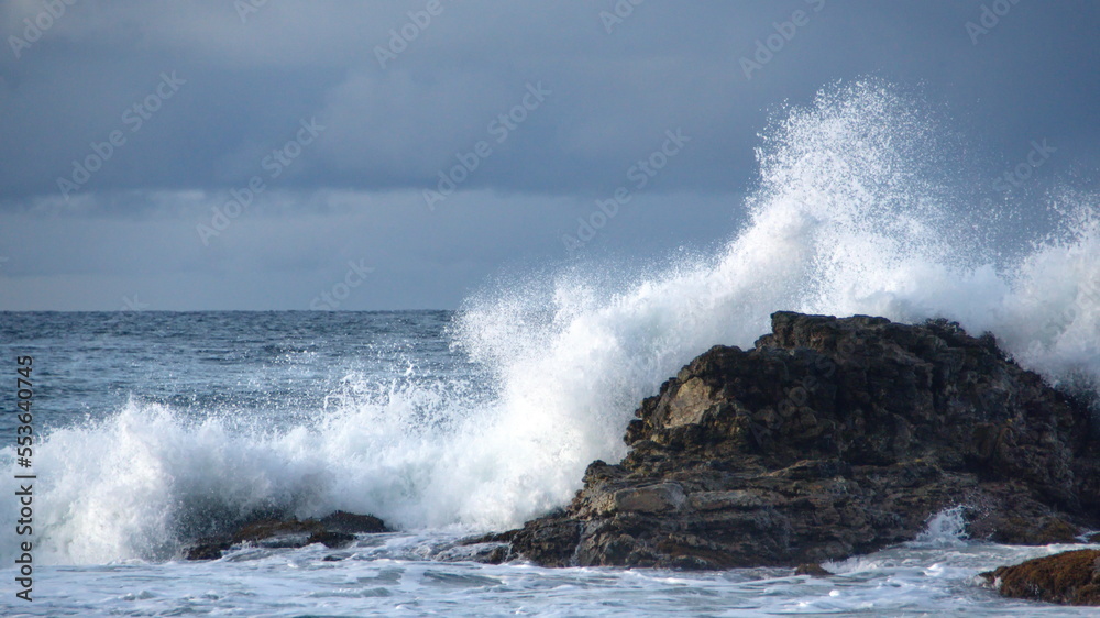 Waves breaking over rocks just off the beach, in the morning, in Zipolite, Mexico