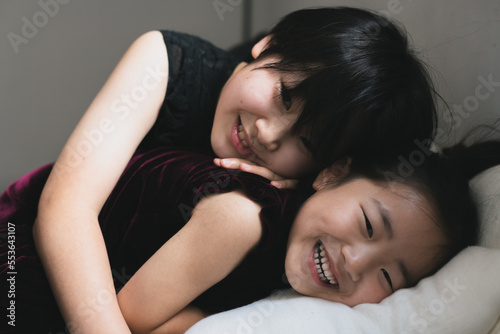 sisters  laughing on a bed photo