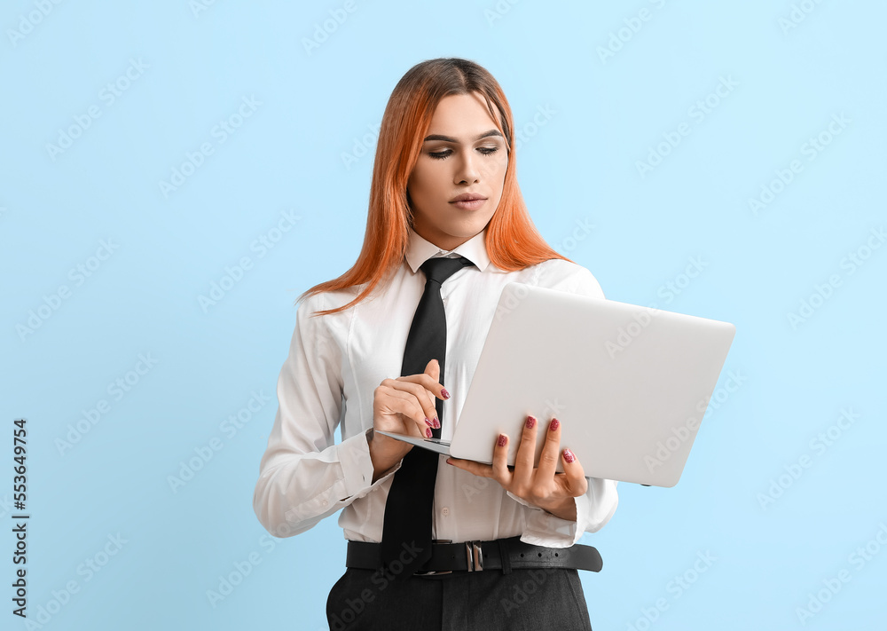 Beautiful transgender secretary with laptop on blue background Beautiful transgender secretary with laptop on blue background