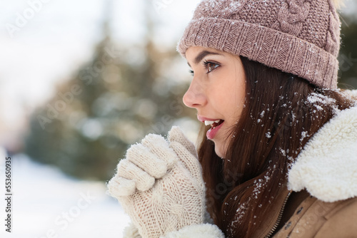 Young woman warming hands o...