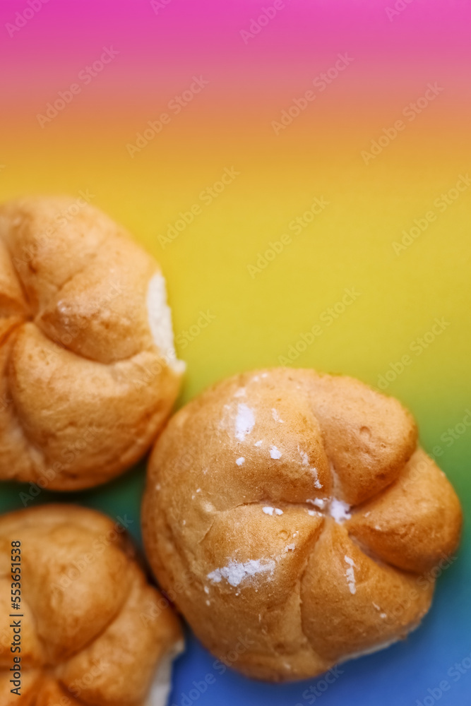 Delicious kaiser rolls on color background