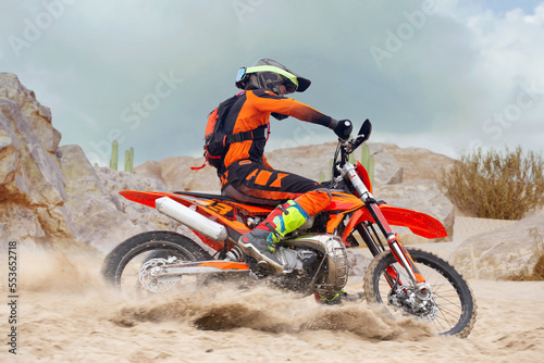 Fototapeta Naklejka Na Ścianę i Meble -  Young man practice riding dirt motorcycle. Splashing sand