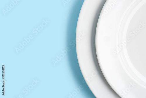 White plates on blue background, closeup