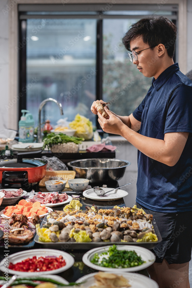 Asian man is preparing seafood feast in the kitchen. Asian man is preparing seafood feast in the kitchen.