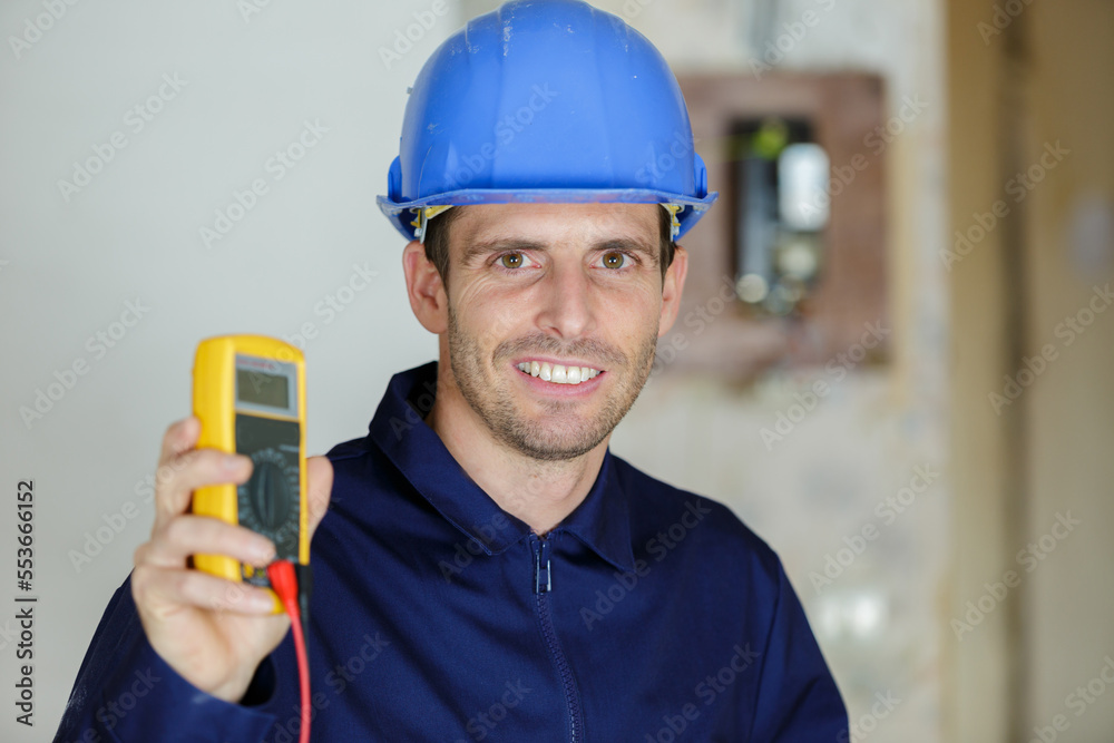 amale electrician is showing multimeter amale electrician is showing multimeter