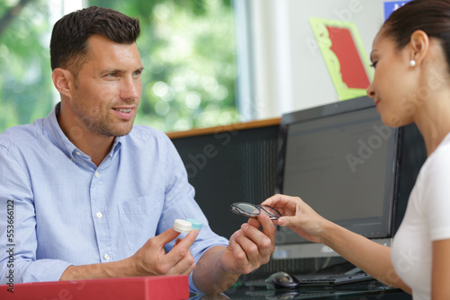 optician discussing benefits of eyeglasses and contact lenses with patient